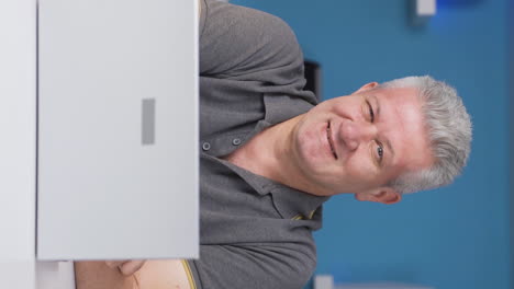 Vertical-video-of-Home-office-worker-man-winks-at-camera.